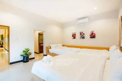 Spacious bedroom with modern decor and two large beds, perfect for comfort and relaxation.