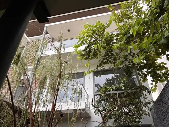 Modern building exterior with lush greenery and large windows