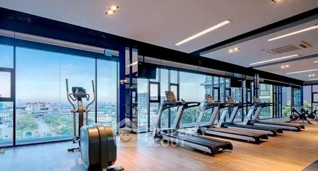 Spacious modern gym with city view and state-of-the-art equipment.