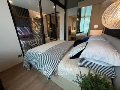 Modern bedroom with stylish decor and large mirror reflecting natural light, creating a spacious feel.