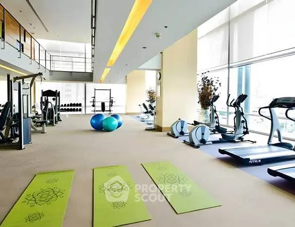 Spacious modern gym with state-of-the-art equipment and natural lighting.