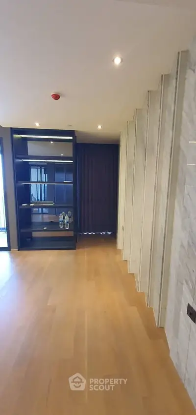 Spacious modern living room with wooden flooring and stylish shelving unit