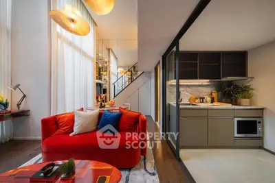 Modern living room with vibrant red sofa and sleek kitchen design