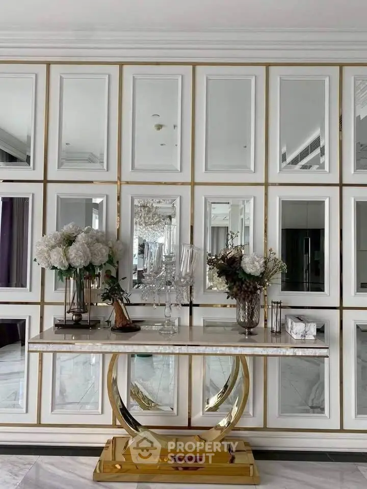 Luxurious interior with elegant console table and mirrored wall panels in a sophisticated living space.