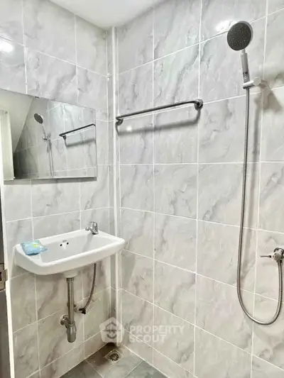 Modern bathroom with sleek tiles and wall-mounted shower