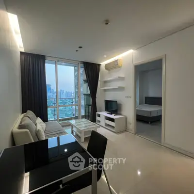 Modern living room with city view, sleek furniture, and open layout in a high-rise apartment.
