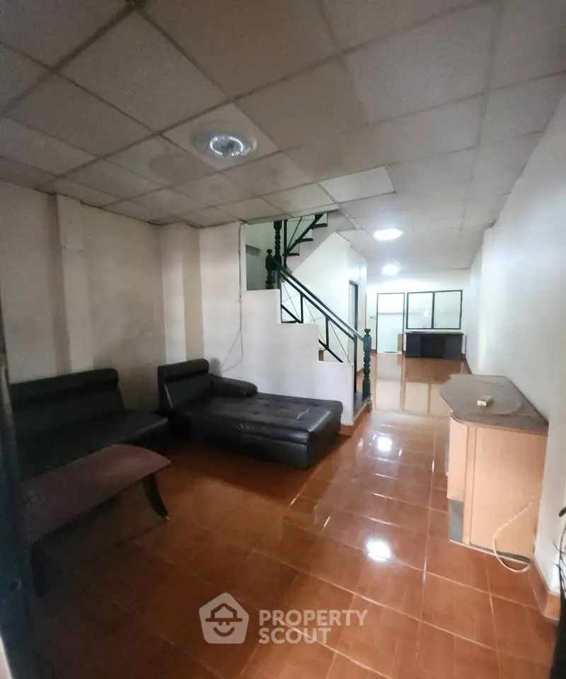 Spacious living room with modern furniture and staircase in a cozy home.