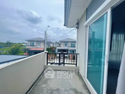 Charming balcony with sliding glass doors and suburban view, perfect for relaxation.