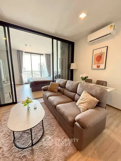 Modern living room with cozy sofa, dining area, and view into bedroom, perfect for urban living.