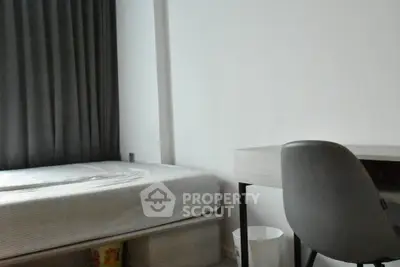 Cozy bedroom with modern desk and comfortable bed, ideal for study or relaxation.