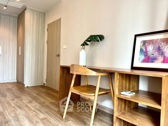 Modern study room with wooden desk and chair, featuring stylish decor and artwork.