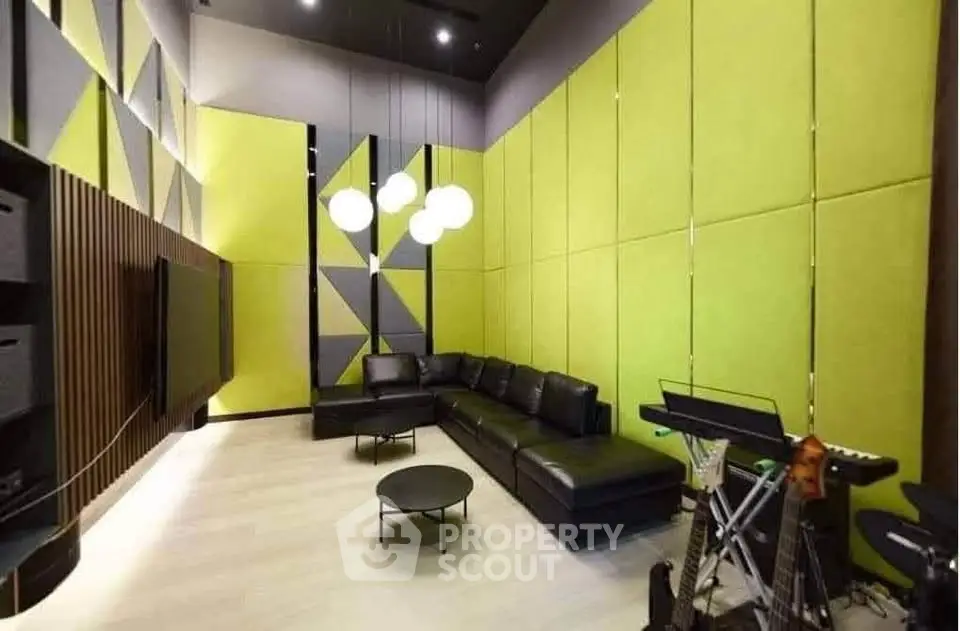 Modern living room with stylish green acoustic panels and black leather sofa, perfect for music enthusiasts.