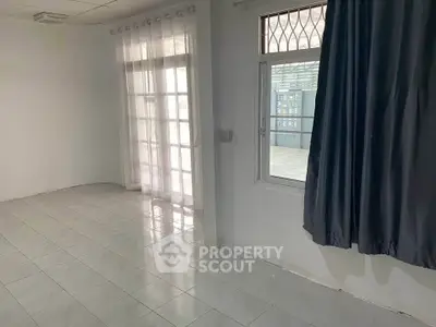 Spacious empty room with tiled floor and large windows, perfect for customization.