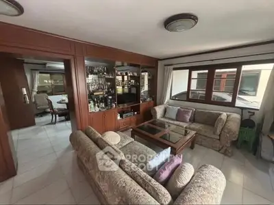 Spacious living room with elegant furniture and built-in wooden shelving, perfect for relaxation and entertainment.