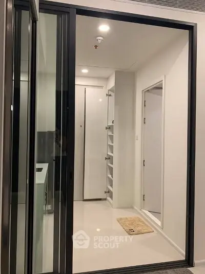 Modern apartment entrance with sleek sliding glass door and minimalist design.