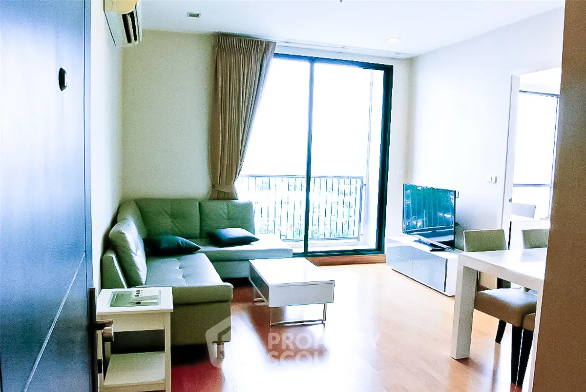 Modern living room with balcony view and stylish furniture in a bright apartment.