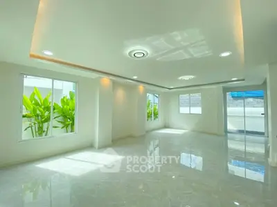 Spacious modern living room with large windows and elegant lighting