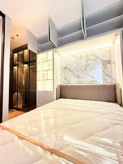 Luxurious bedroom with elegant marble wall and built-in storage, featuring a plush bed and modern glass wardrobe.
