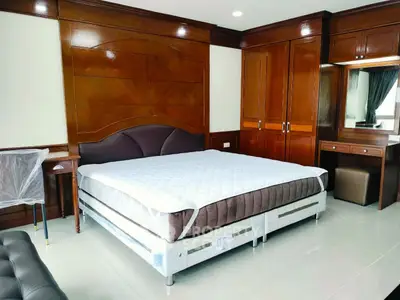 Spacious bedroom with elegant wooden furnishings and large bed