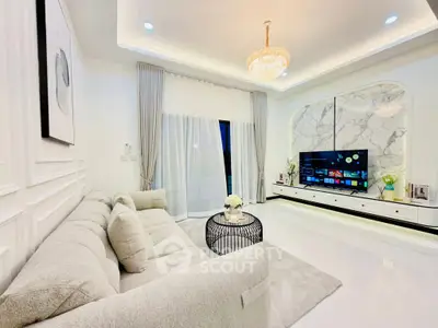 Luxurious modern living room with elegant chandelier and sleek entertainment center.