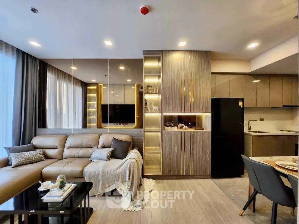 Modern living room with sleek kitchen and cozy seating area in luxury apartment.