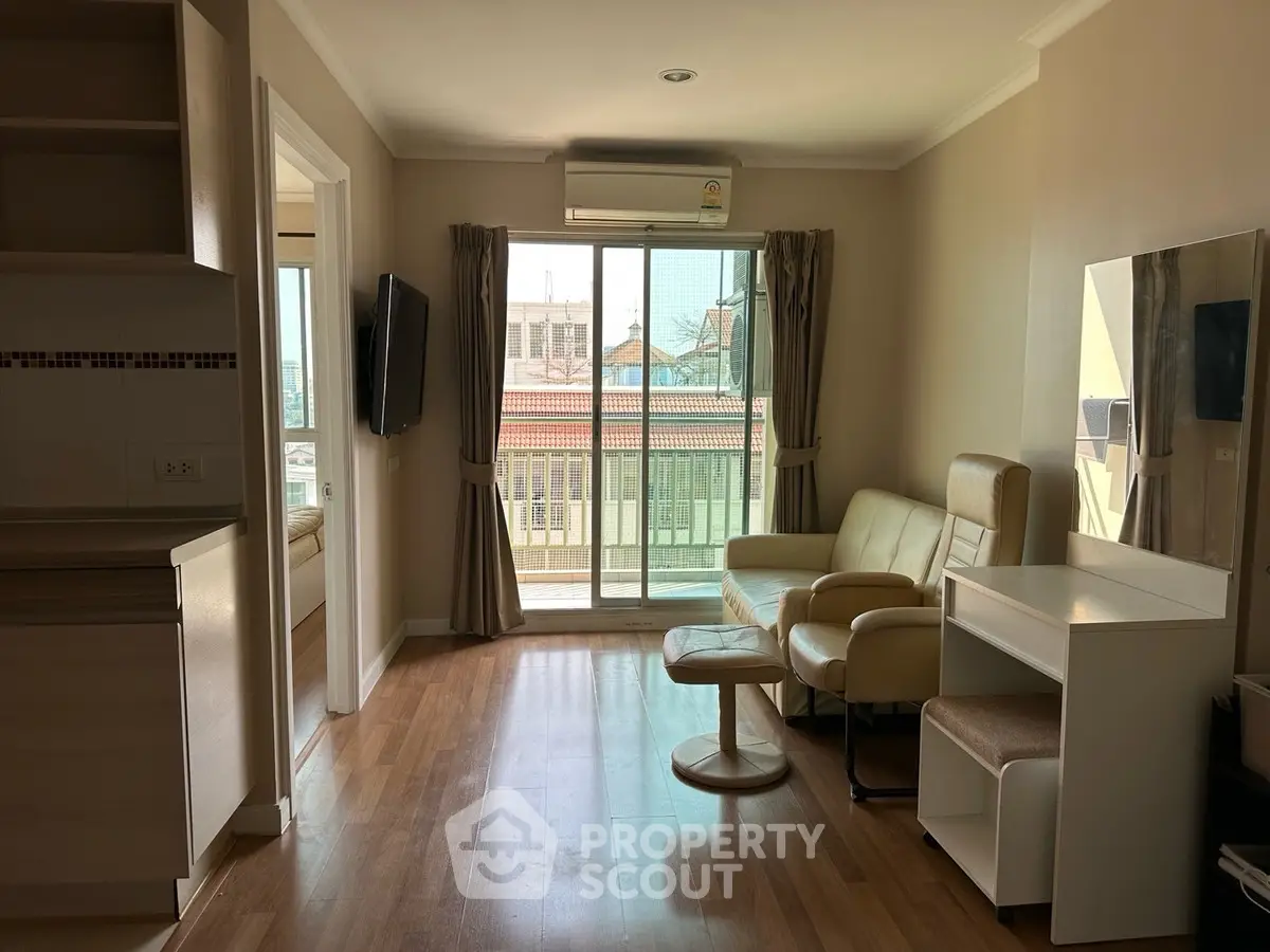 Modern living room with balcony view, featuring stylish furniture and natural light.