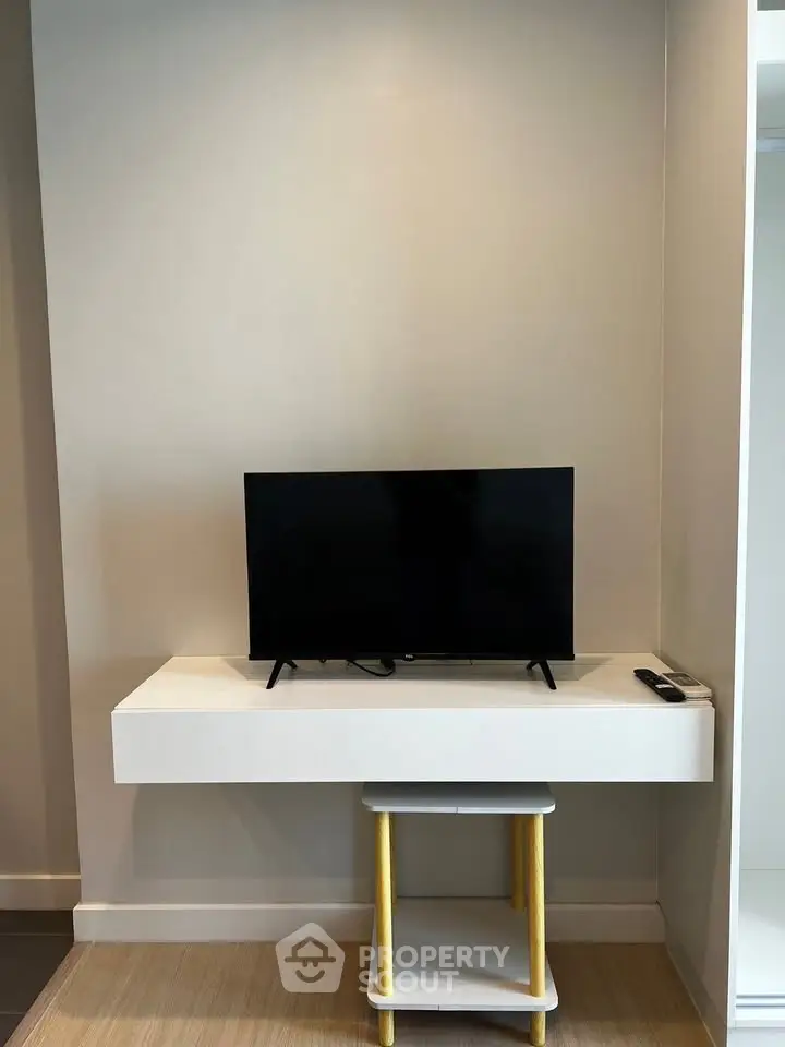 Modern living room with sleek TV setup on minimalist white console table.