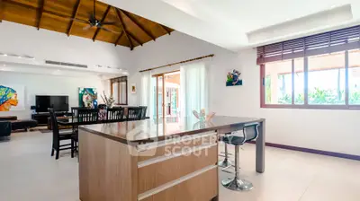 Spacious open-plan living room with modern kitchen and high ceilings