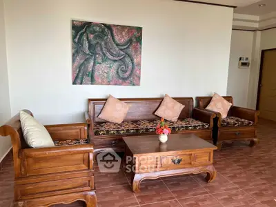 Charming living room with elegant wooden furniture and artistic elephant painting.