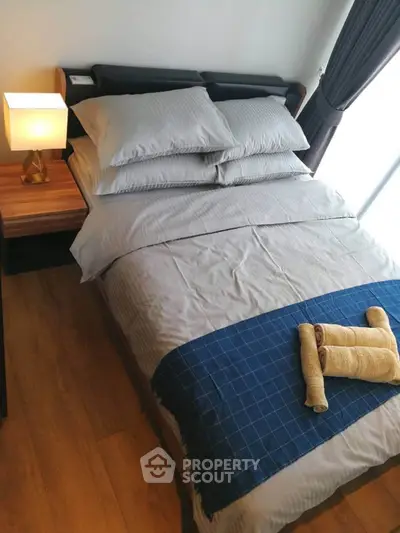 Cozy bedroom with stylish bedding and natural light, perfect for relaxation.