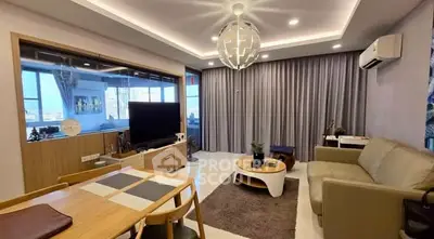 Modern living room with stylish decor and large windows offering city views.