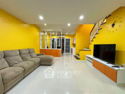 Spacious modern living room with vibrant yellow walls and sleek staircase