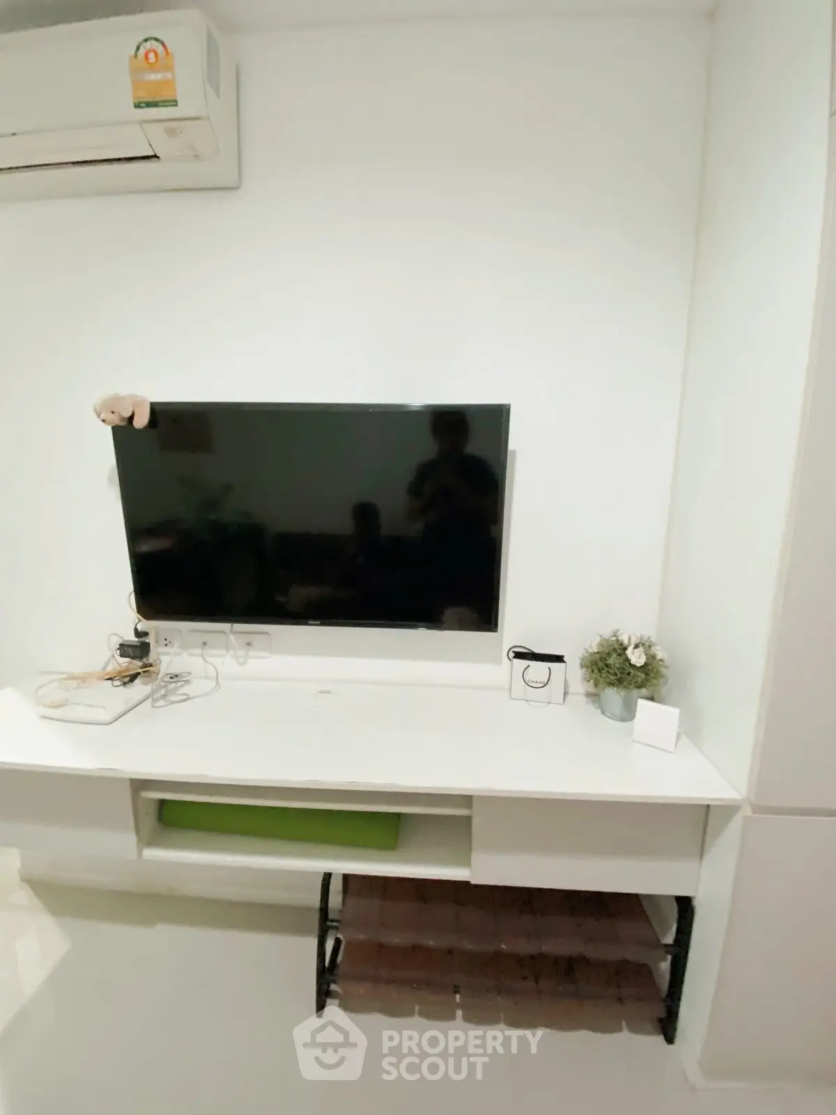 Modern living room with wall-mounted TV and sleek white furniture