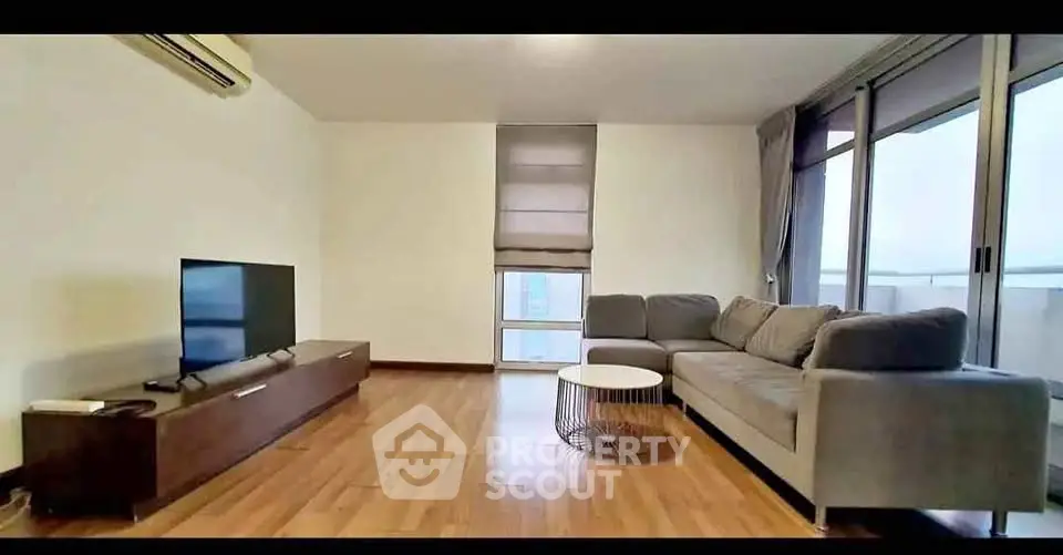 Spacious modern living room with sleek furniture and large windows for natural light.