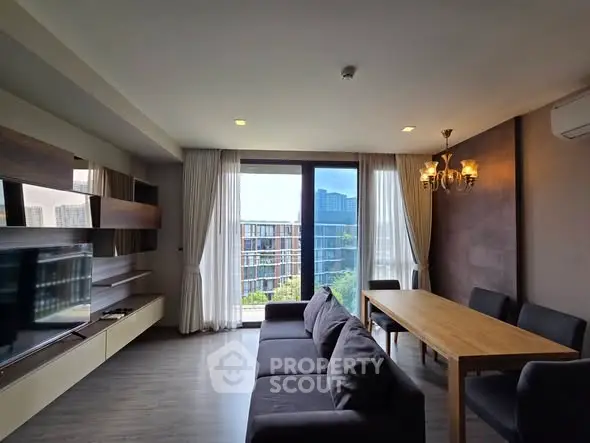 Modern living room with large windows and city view, featuring sleek furniture and elegant lighting.