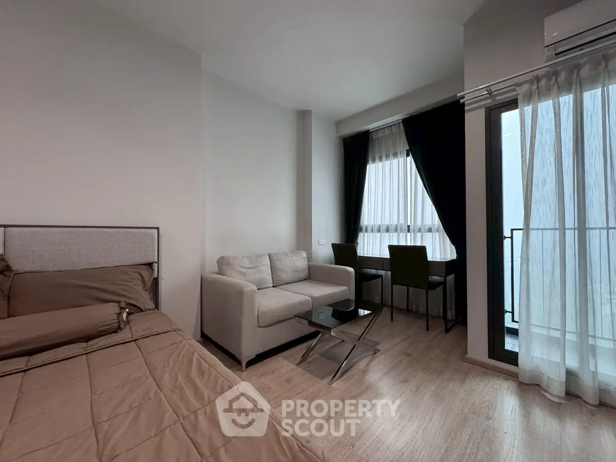 Modern studio apartment with cozy living area and balcony view