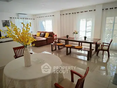 Spacious and bright living room with elegant dining area and cozy seating, perfect for family gatherings.