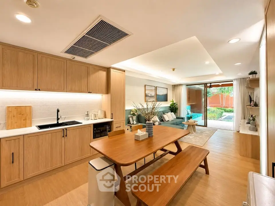 Spacious open-plan living room with modern kitchen and garden view, perfect for family gatherings.