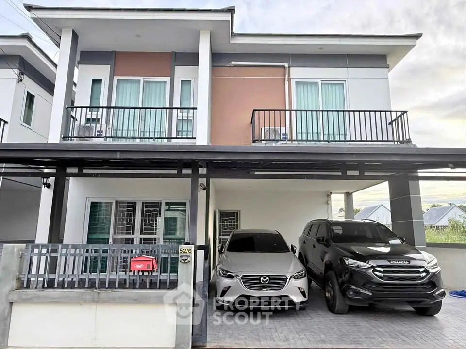 Modern two-story house with spacious driveway and two parked cars.