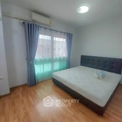 Spacious bedroom with large window and modern decor