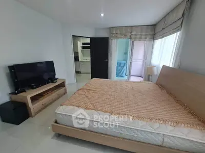 Spacious bedroom with modern decor and natural light in a stylish apartment.