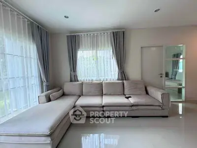 Spacious living room with elegant corner sofa and large windows