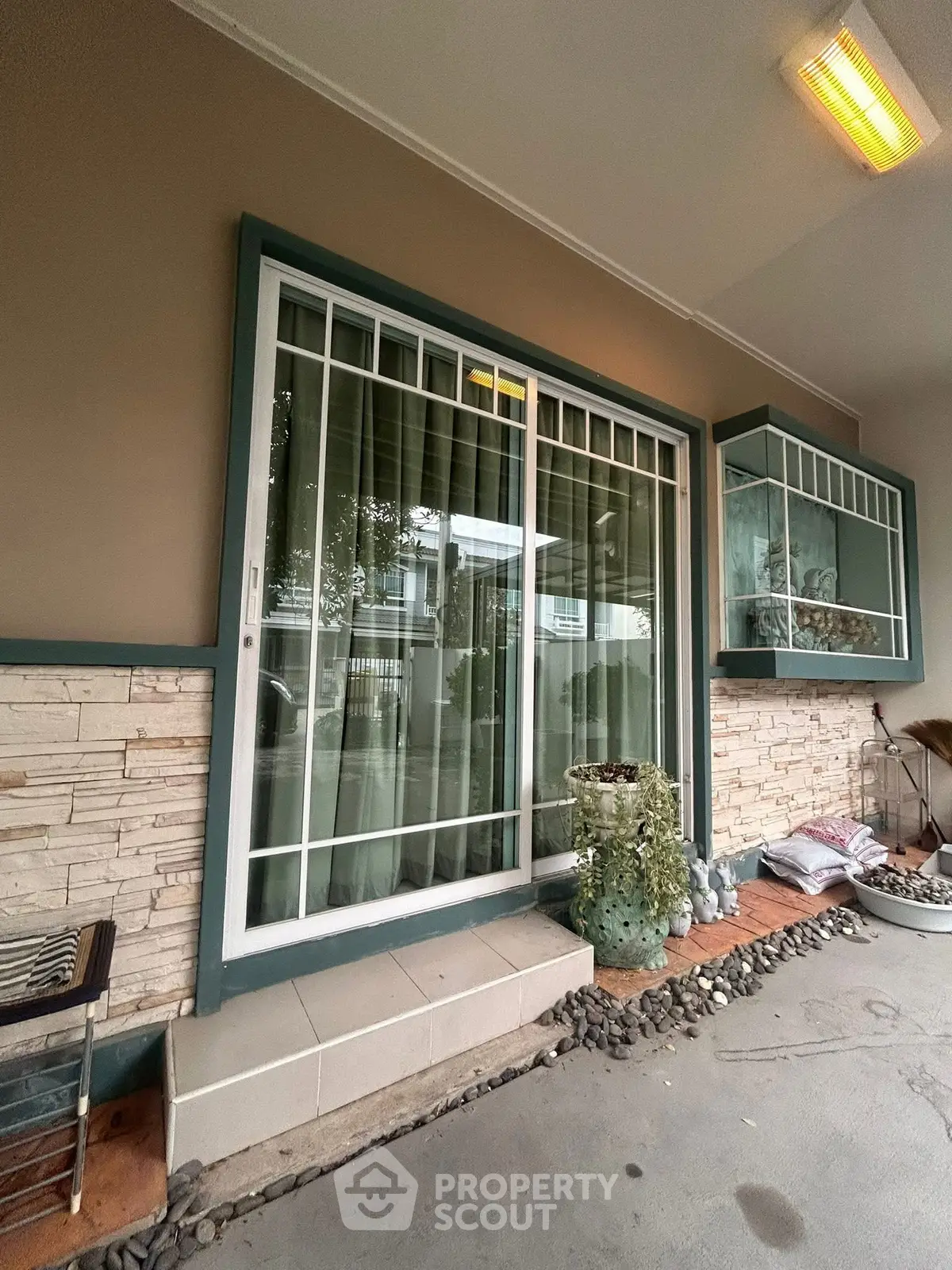 Charming exterior view with sliding glass door and decorative stone wall accents.