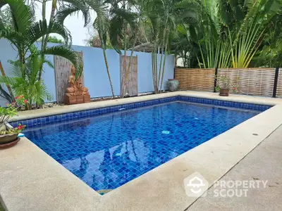 Stunning private pool surrounded by lush greenery in a serene backyard setting.