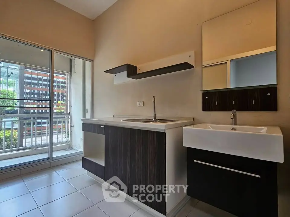 Modern kitchen with sleek cabinetry and balcony view in urban apartment