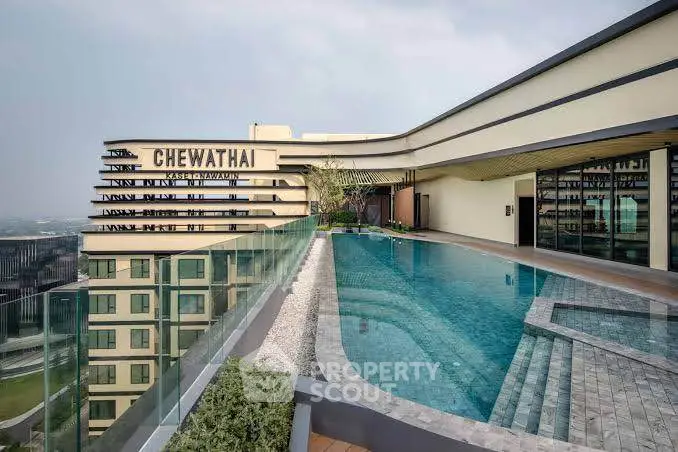 Luxurious rooftop pool with stunning city views at modern high-rise building.