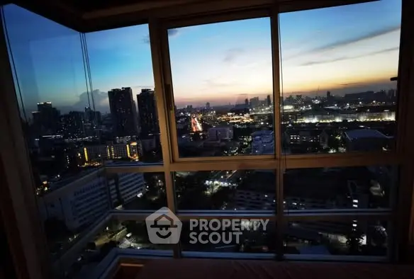 Stunning cityscape view from high-rise apartment window at sunset.