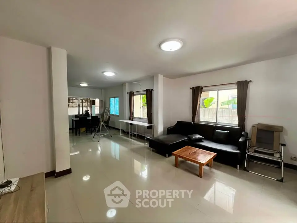 Spacious living room with modern furniture and natural light, perfect for relaxation and entertainment.