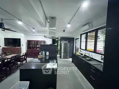 Modern open-layout kitchen with sleek black cabinetry and stainless steel appliances