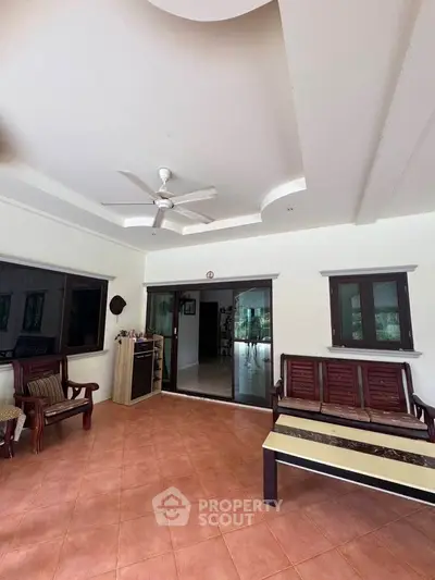 Spacious living room with elegant ceiling design and wooden furniture, perfect for relaxation and gatherings.